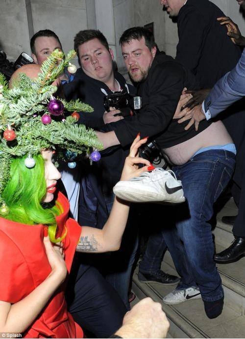 Lady gaga dressed as Christmas tree stealing shoe from fat man