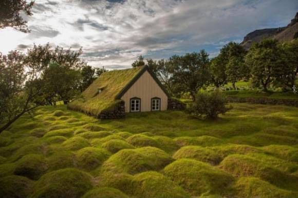 This picture taken in Iceland in the late afternoon. On the picture is a little church made from wood and peat