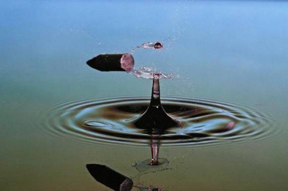 A bullet splitting a water droplet in half