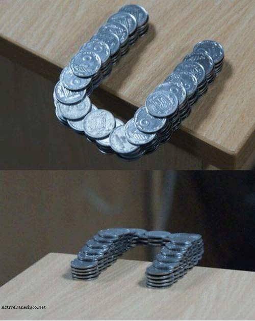 Coins stacked in such a way that they extend past the edge of the table.