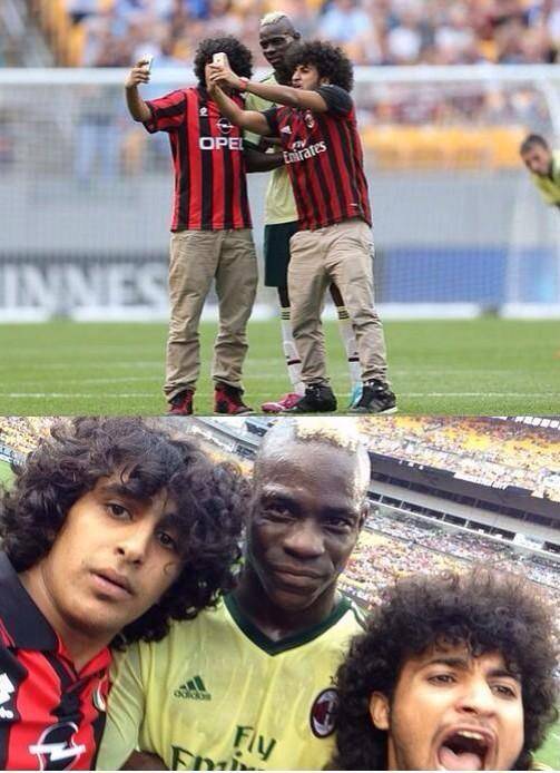 Mario Balotelli takes a selfie mid match with two pitch invaders.