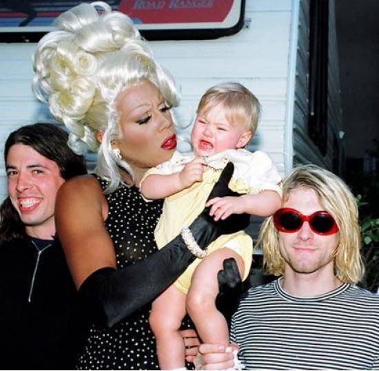 Dave Grohl and Kurt Cobain smirk whilst a flustered RuPaul tries to console a screaming Frances Bean.