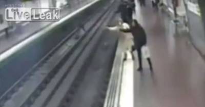 Heartstopping Moment Off-Duty Cop Saves Drunk Man On Tracks Moments Before Train Speeds Through Station