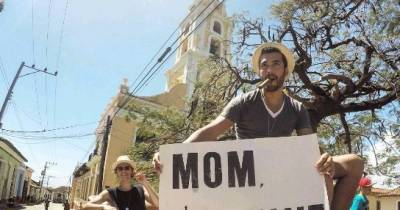 Dude Travels The World With A Sweet 'Mom, I'm Fine' Sign
