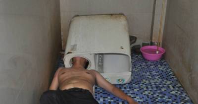 Man Tries To Fix His Broken Washing Machine, Gets His Head Hilariously Stuck Instead