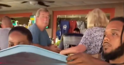 White Man Stares At Black Family Enjoying Their Meal